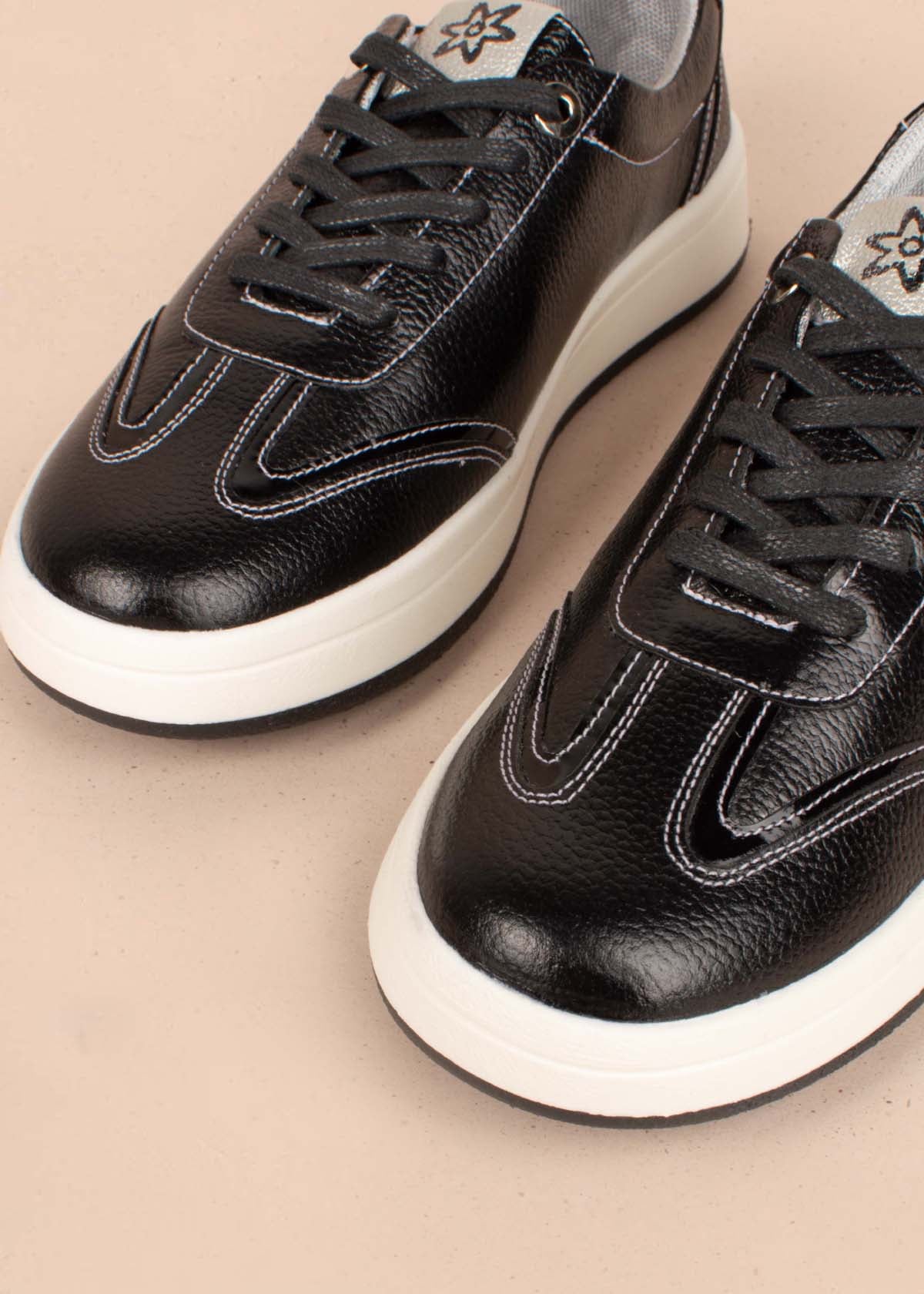 Tenis casuales en cuero color negro con costuras blancas 104777