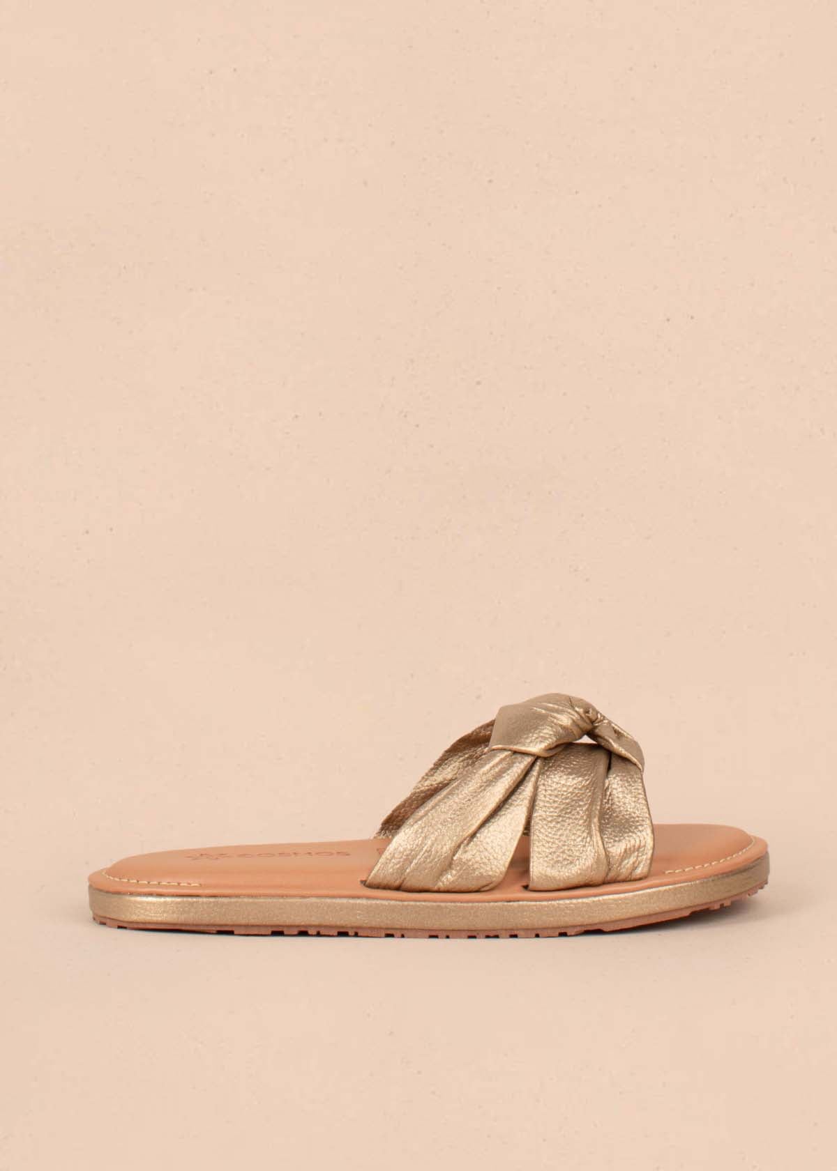 Sandalias planas en cuero color champaña con nudo decorativo 104791