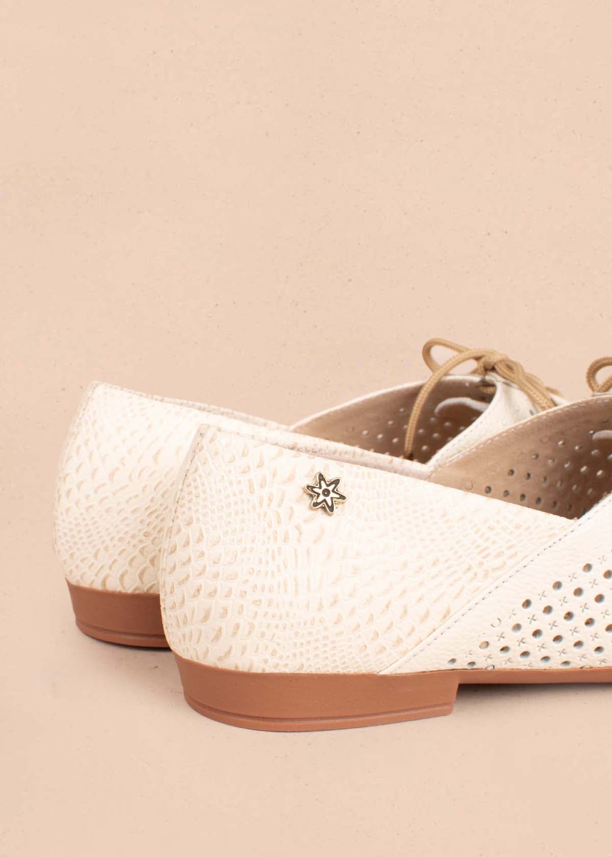 Zapatos cerrados en cuero color talco con perforaciones y moño104916