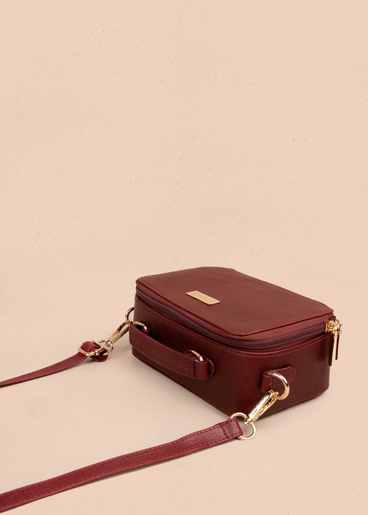 Bolso tipo bandolera color vinotinto con asa superior y acabado elegante 105314