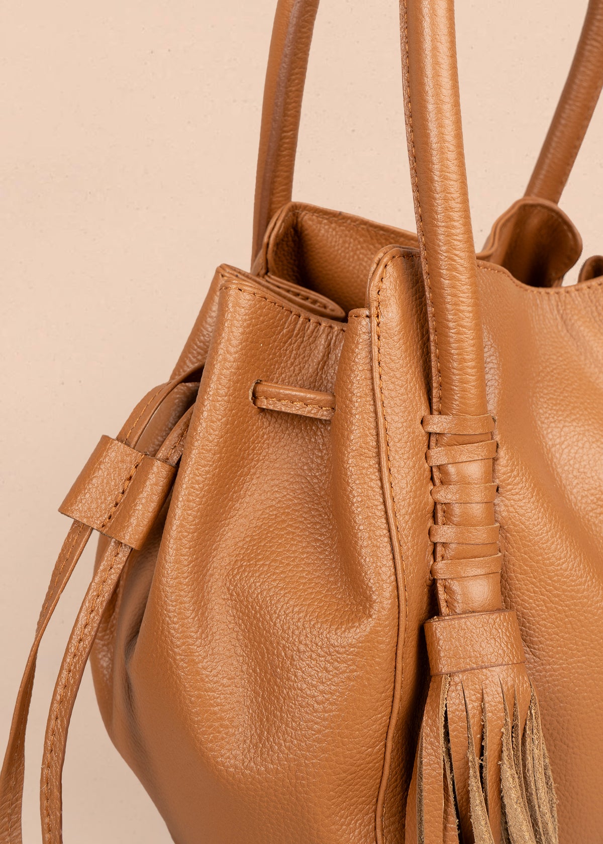 Bolso tipo cartera en cuero color miel con flecos 105787