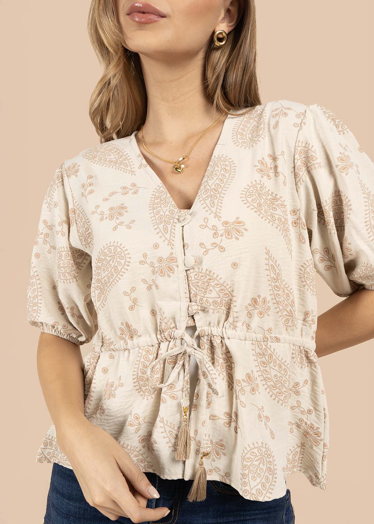 Blusa color beige con diseño floral y cordón con borlas 105837