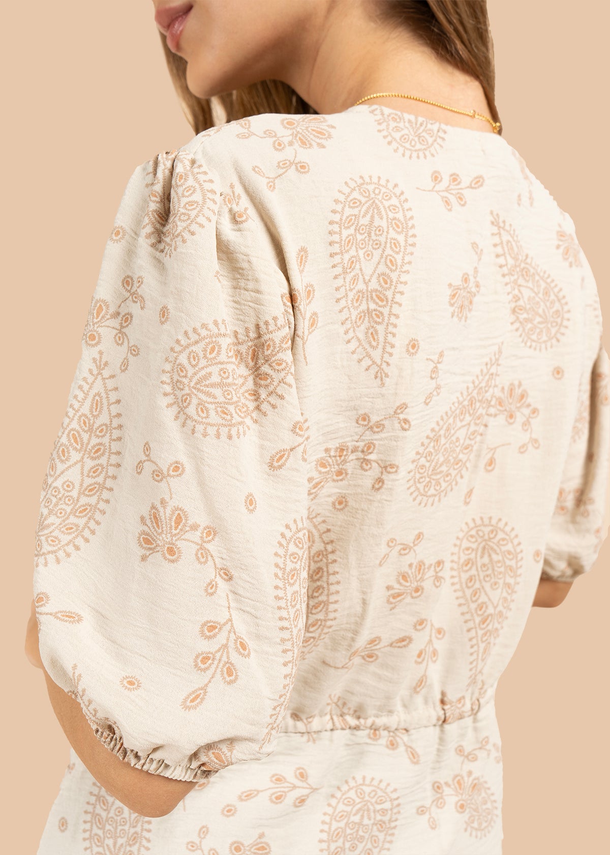 Blusa color beige con diseño floral y cordón con borlas 105837