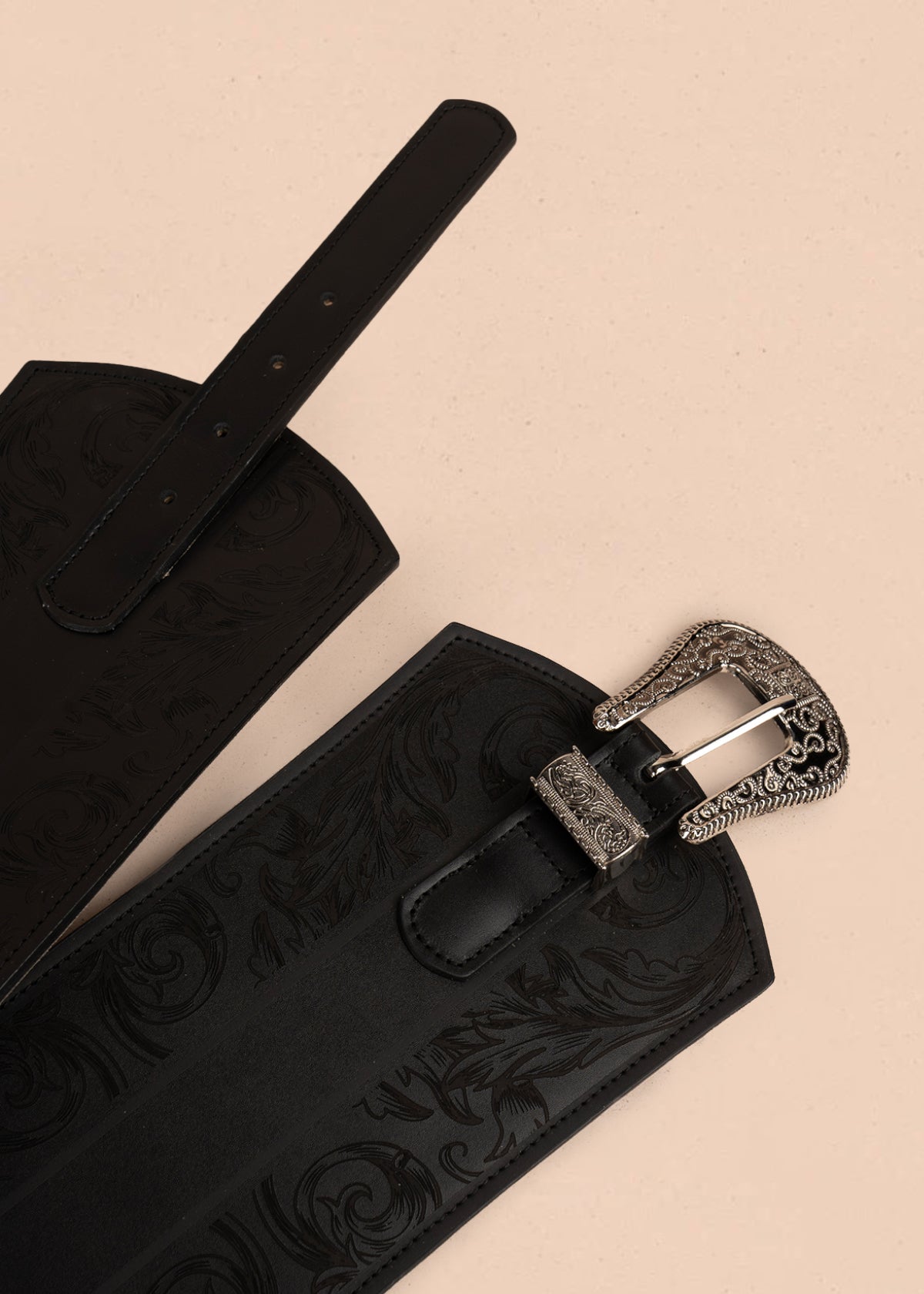 Cinturón en cuero negro con hebilla plateada y grabado floral en relive 105889