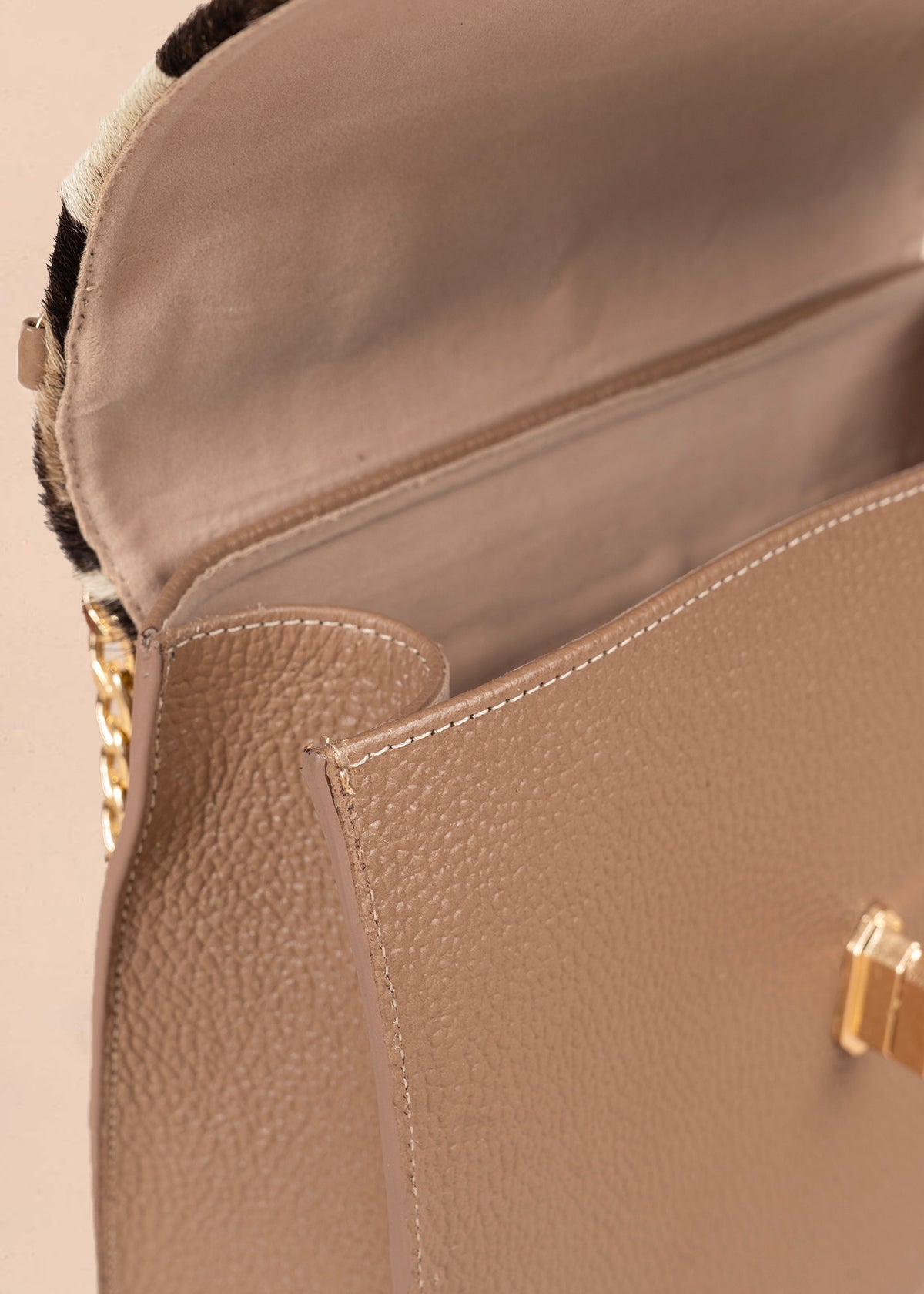 Bolso manos libres en cuero color café con estampado animal print y cadena dorada 105934