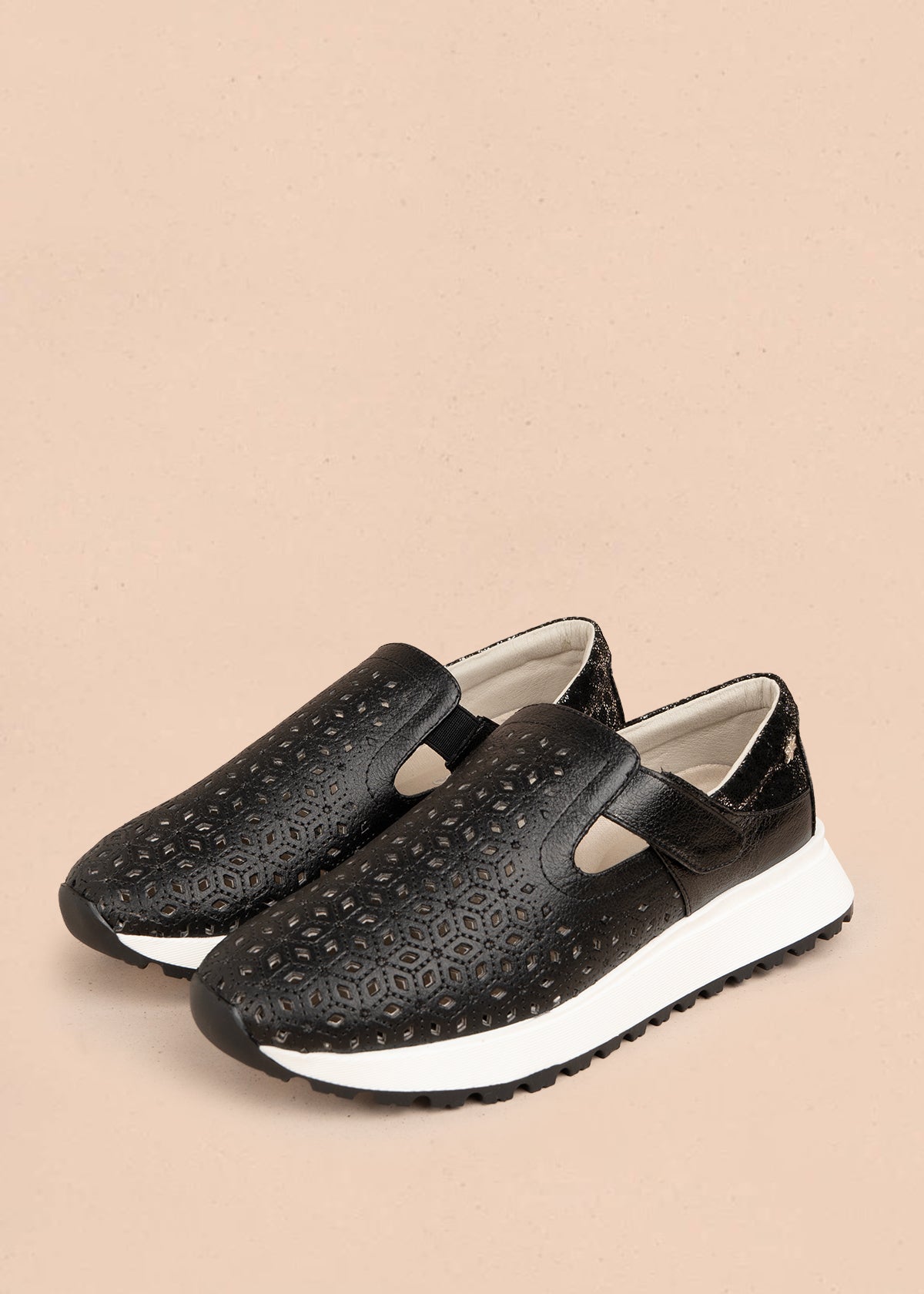 Zapato cerrado en cuero color negro con talón dorado y patrón troquelado 106018