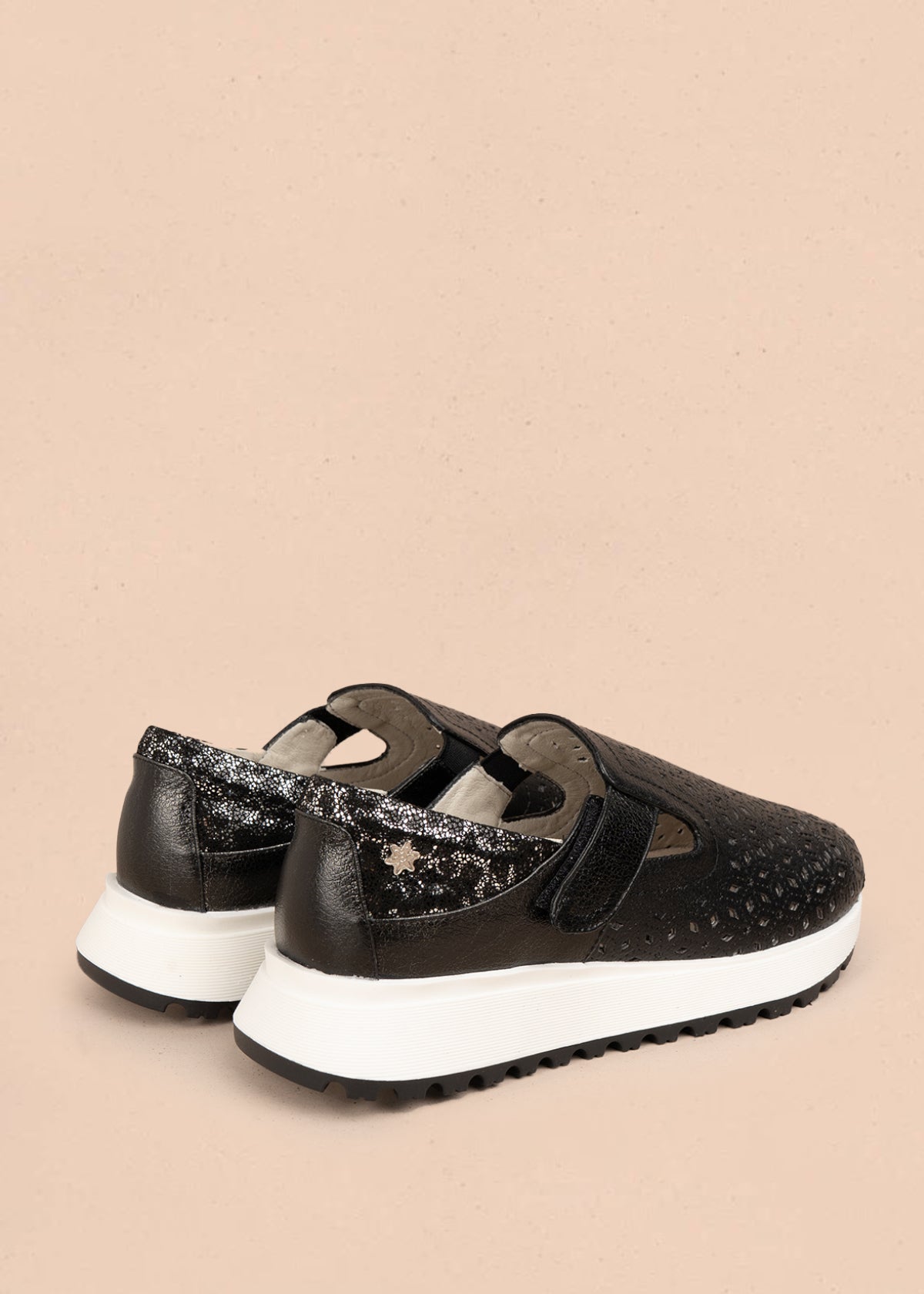Zapato cerrado en cuero color negro con talón dorado y patrón troquelado 106018