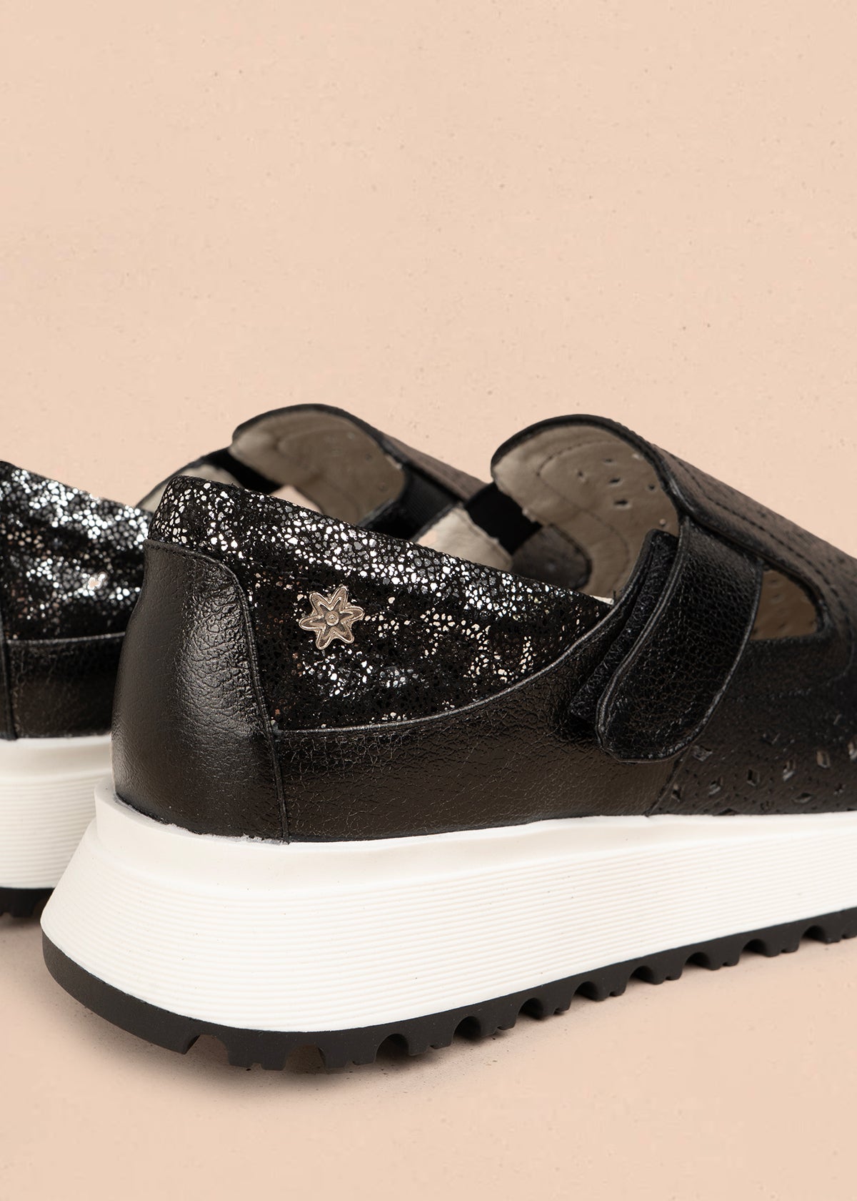 Zapato cerrado en cuero color negro con talón dorado y patrón troquelado 106018