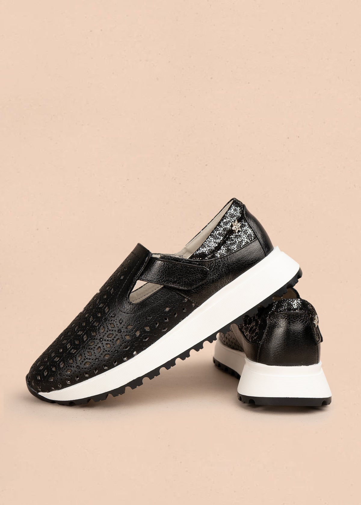 Zapato cerrado en cuero color negro con talón dorado y patrón troquelado 106018