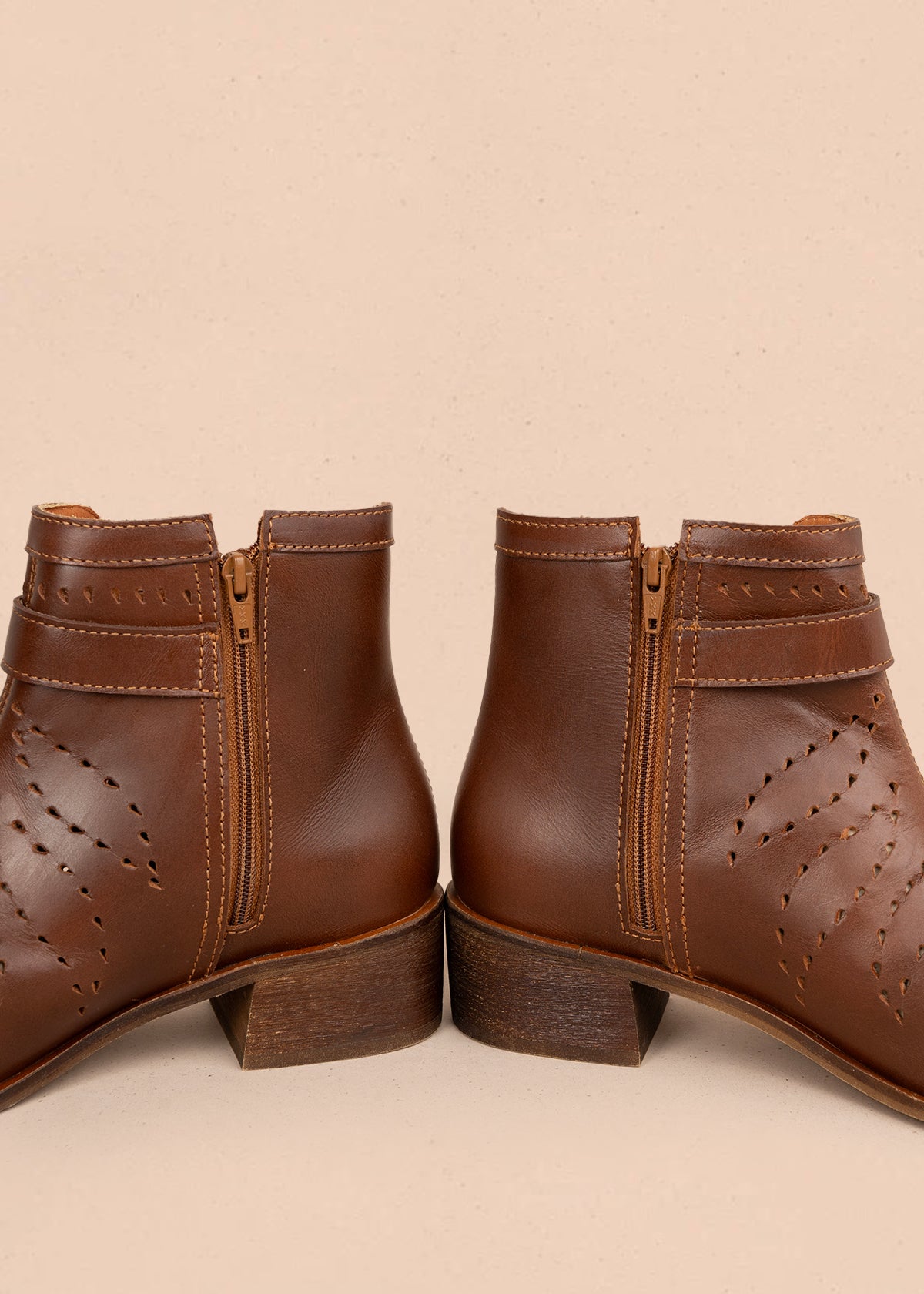 Botines en cuero color café con detalles perforados y hebilla decorativa 106111