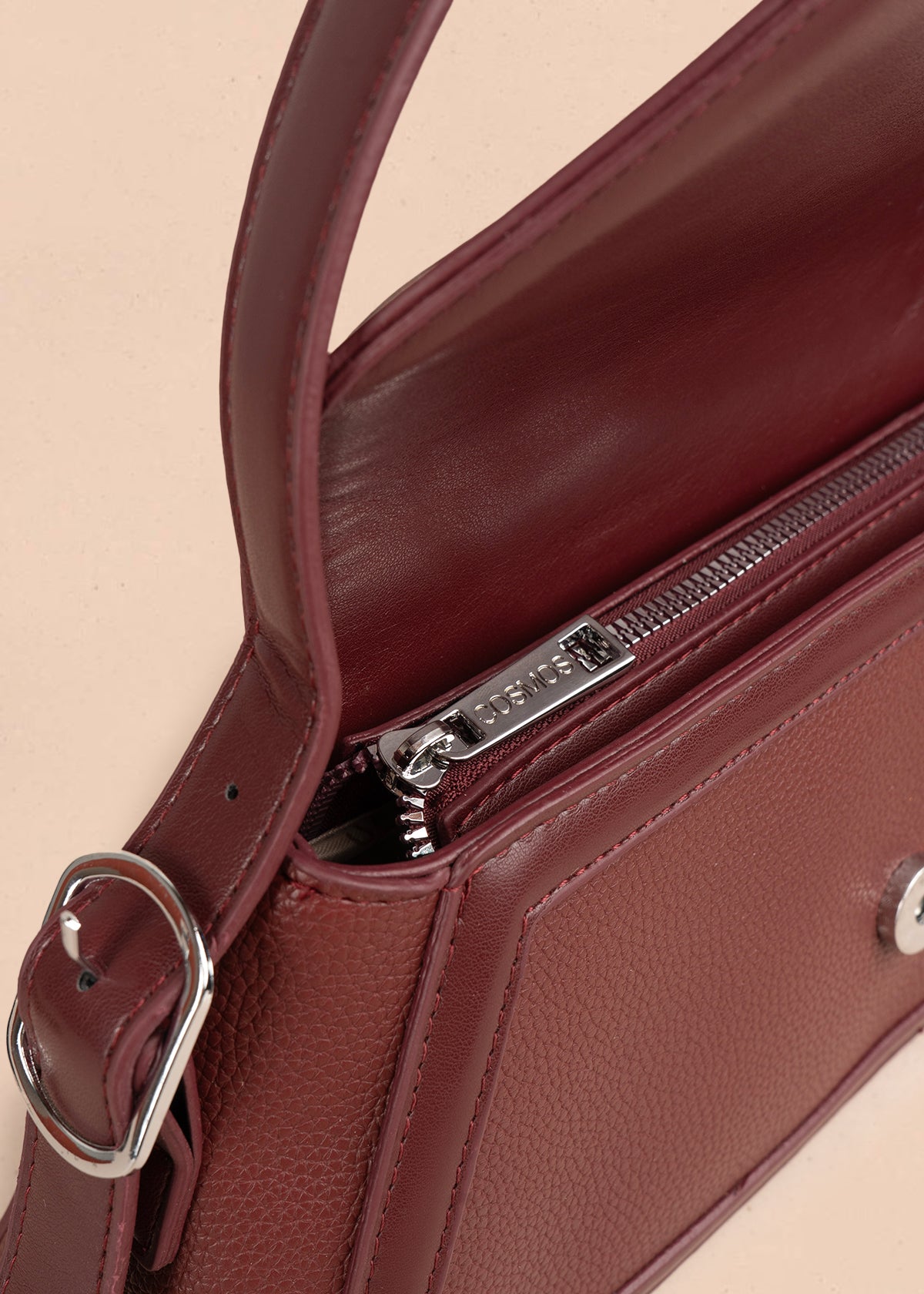 Bolso cartera color vinotinto con diseño triangular y acabados metálicos 106179