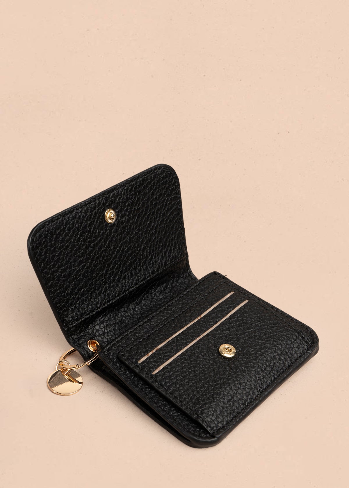 Billetera pequeña color negro con cierre de solapa y aplique dorado 106185