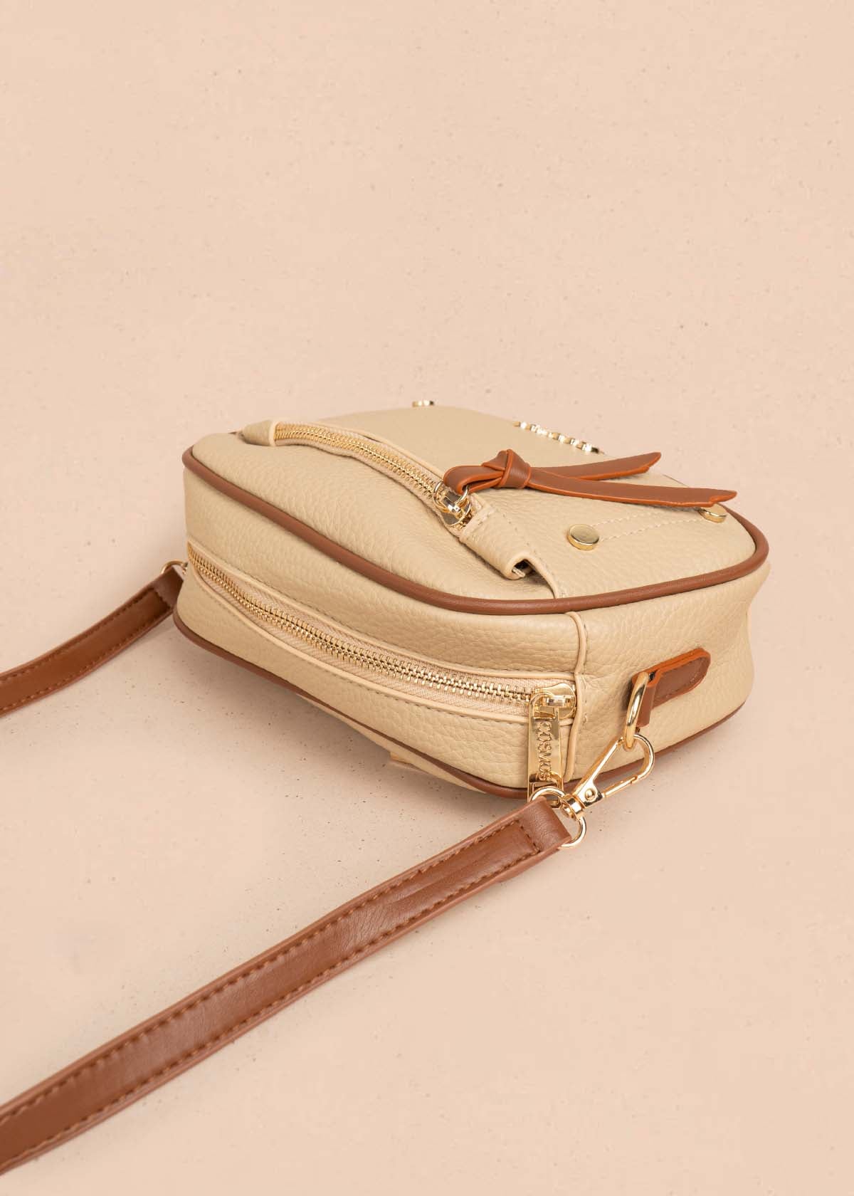 Bolso manos libres color moca bicolor con ribete y tachuelas doradas 106332