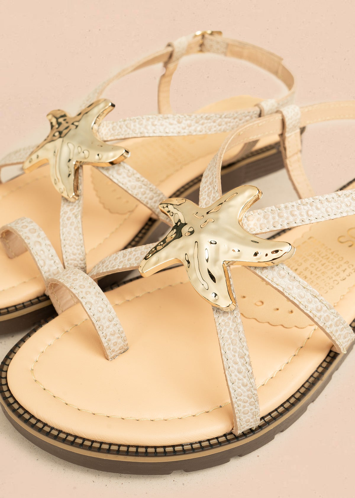 Sandalias planas color blanco con detalle de estrella marina metálica 106519