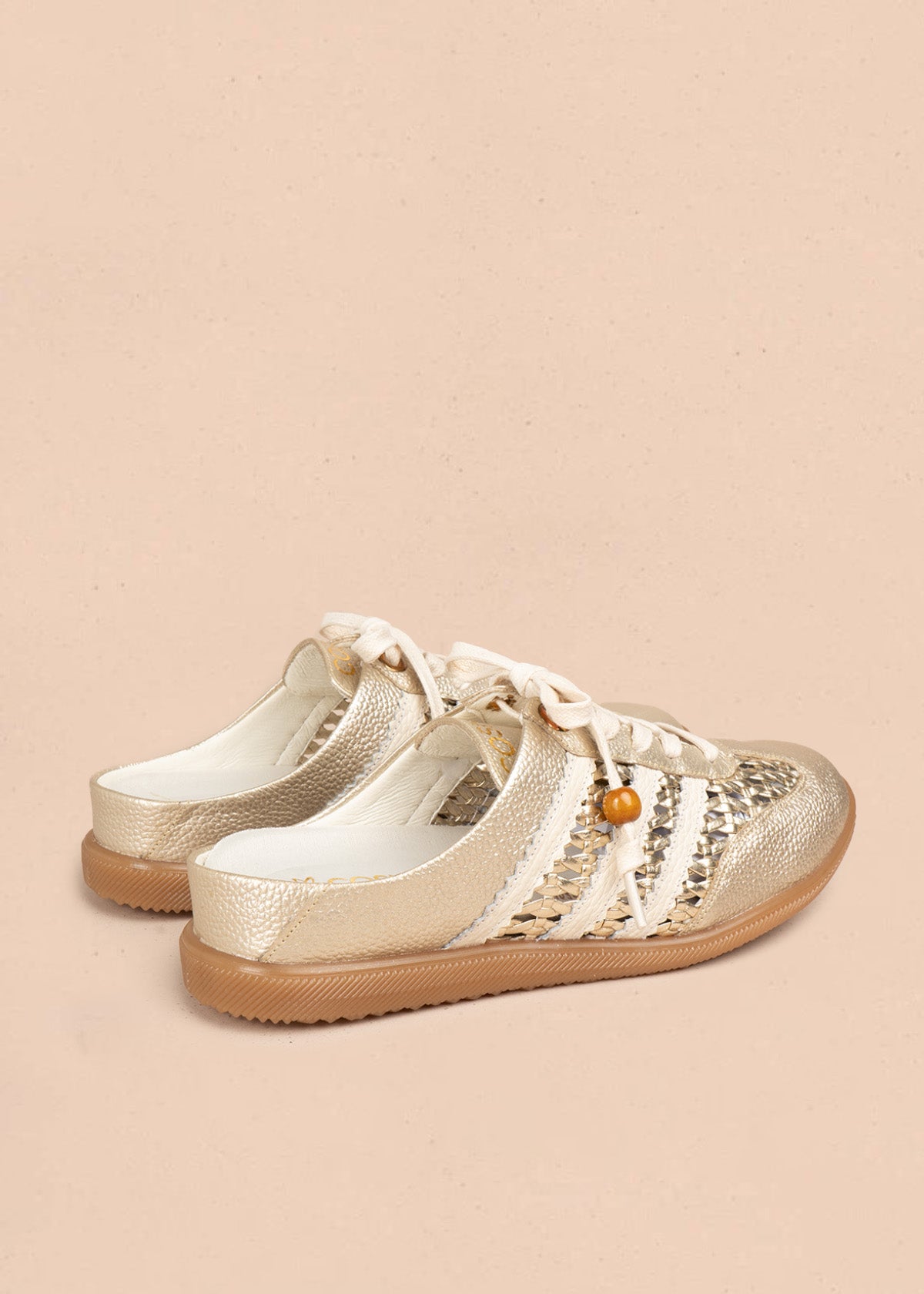 Zuecos en cuero color dorado con tejido, detalle leopardo y cordón con cuenta de madera 106932