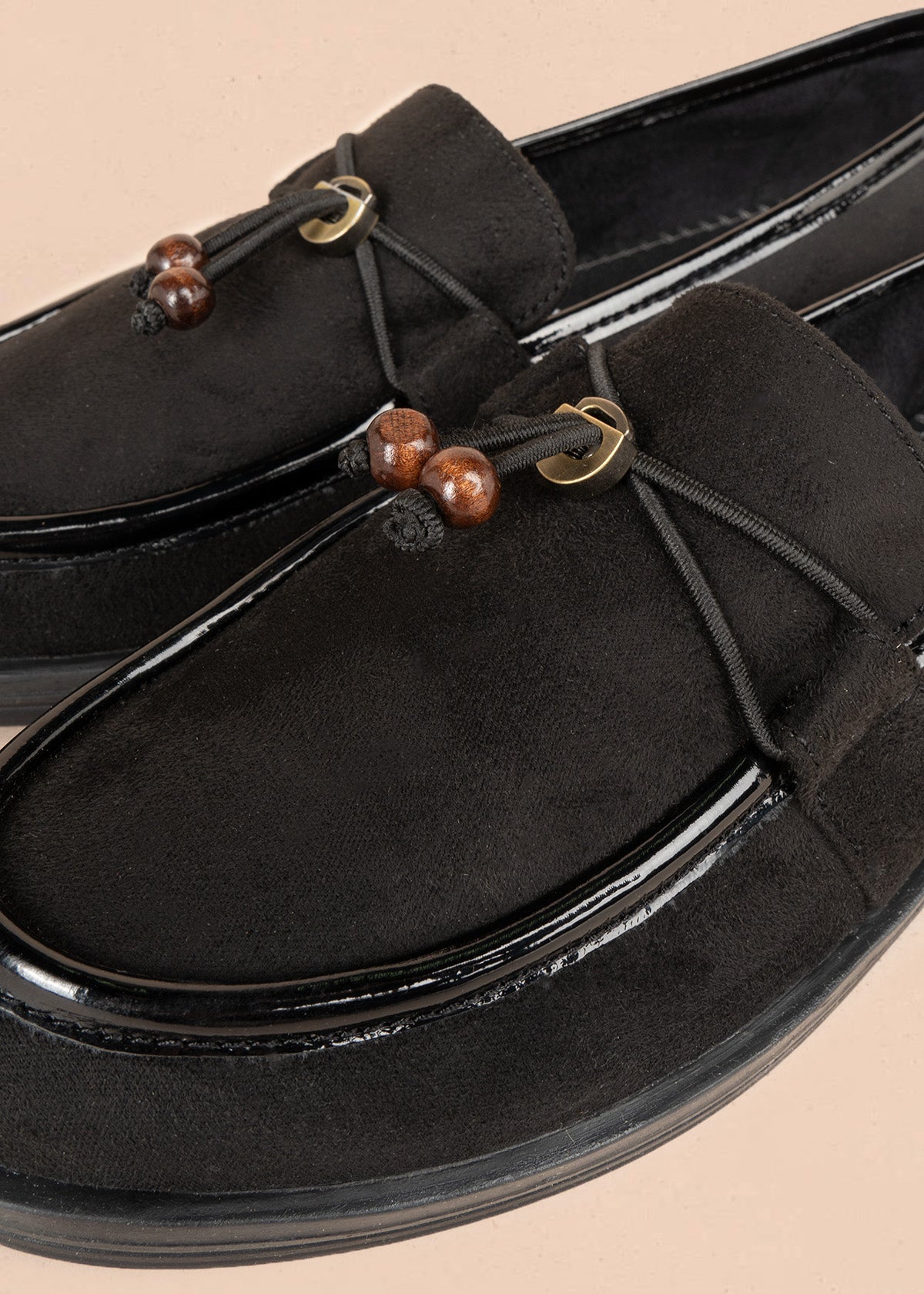 mocasín negro con ribete de charol y logo floral metálico 106950