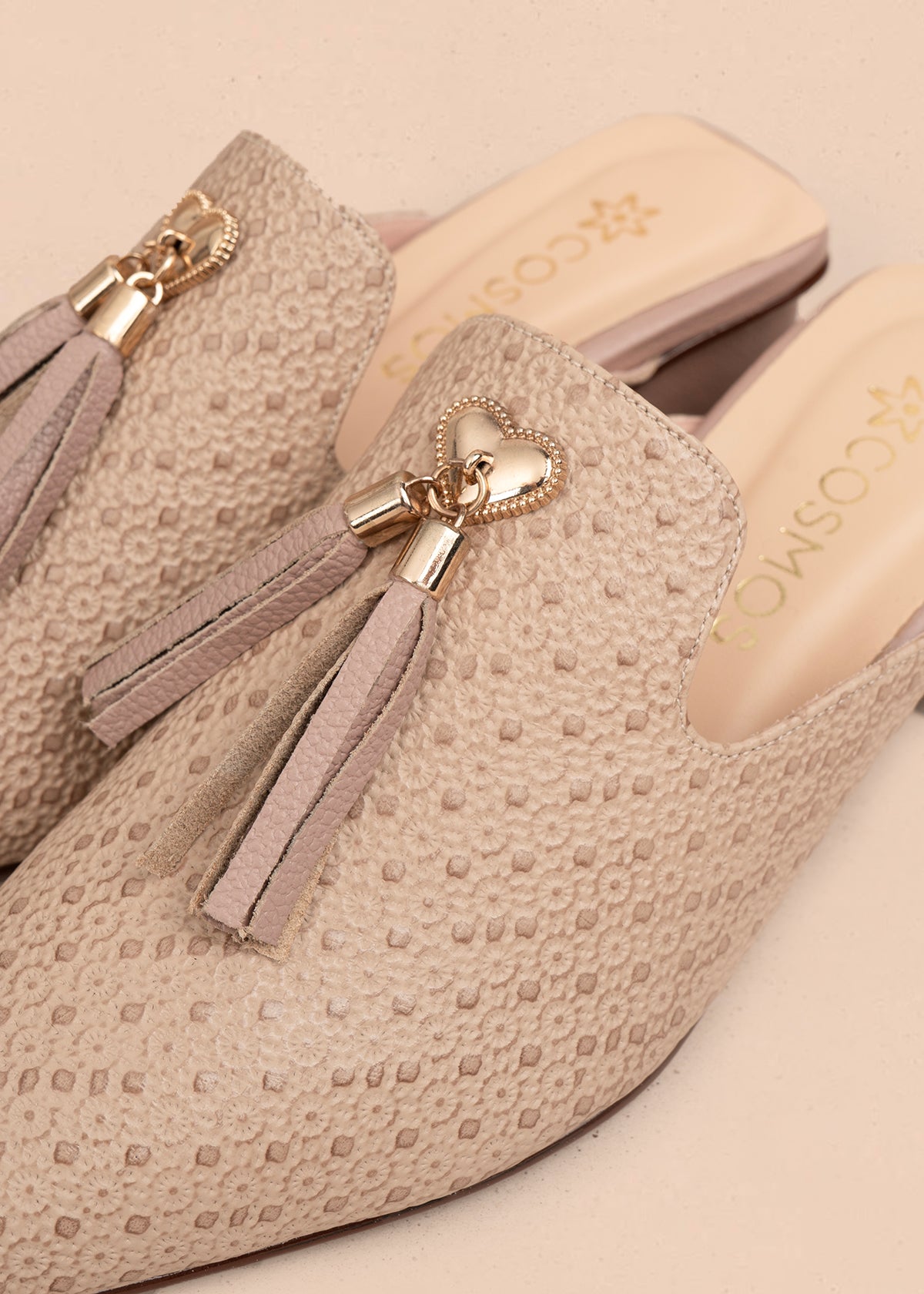 Zuecos en cuero color taupe con textura y adorno de corazón y borlas 107002