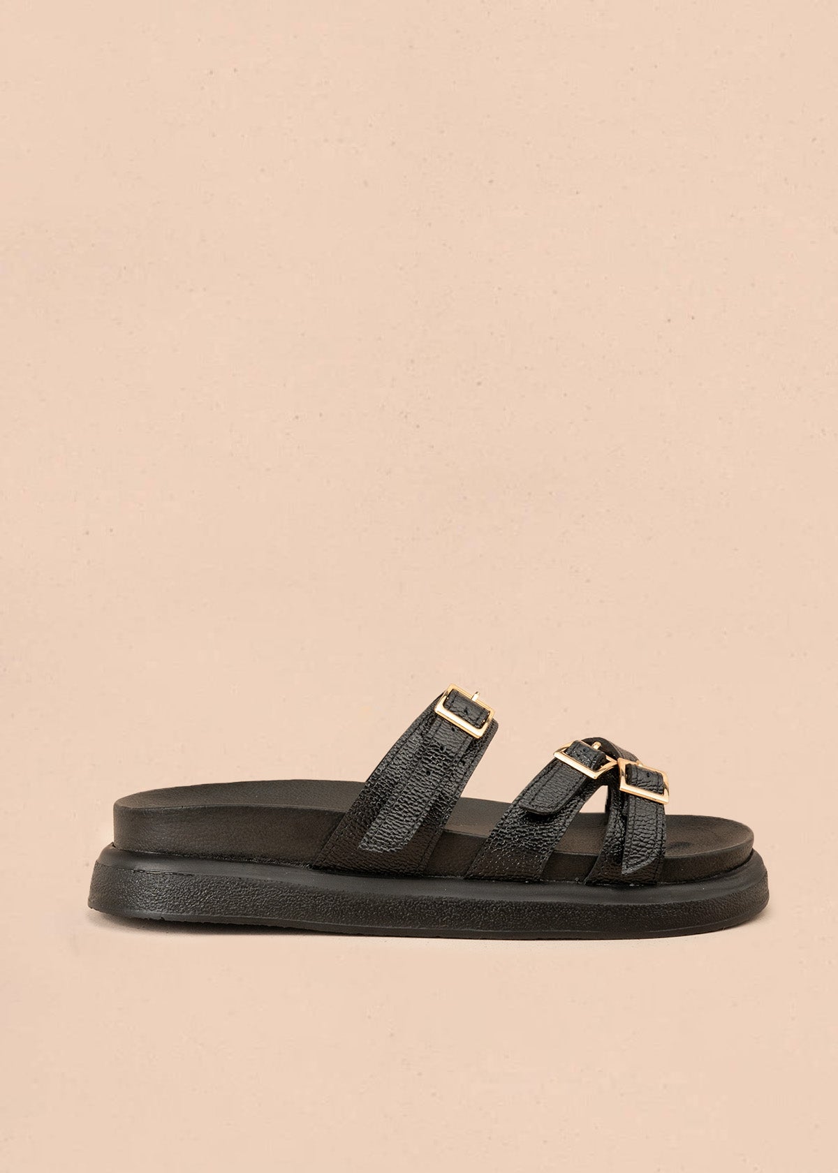 Sandalia plana en cuero color negro con hebillas doradas 107091
