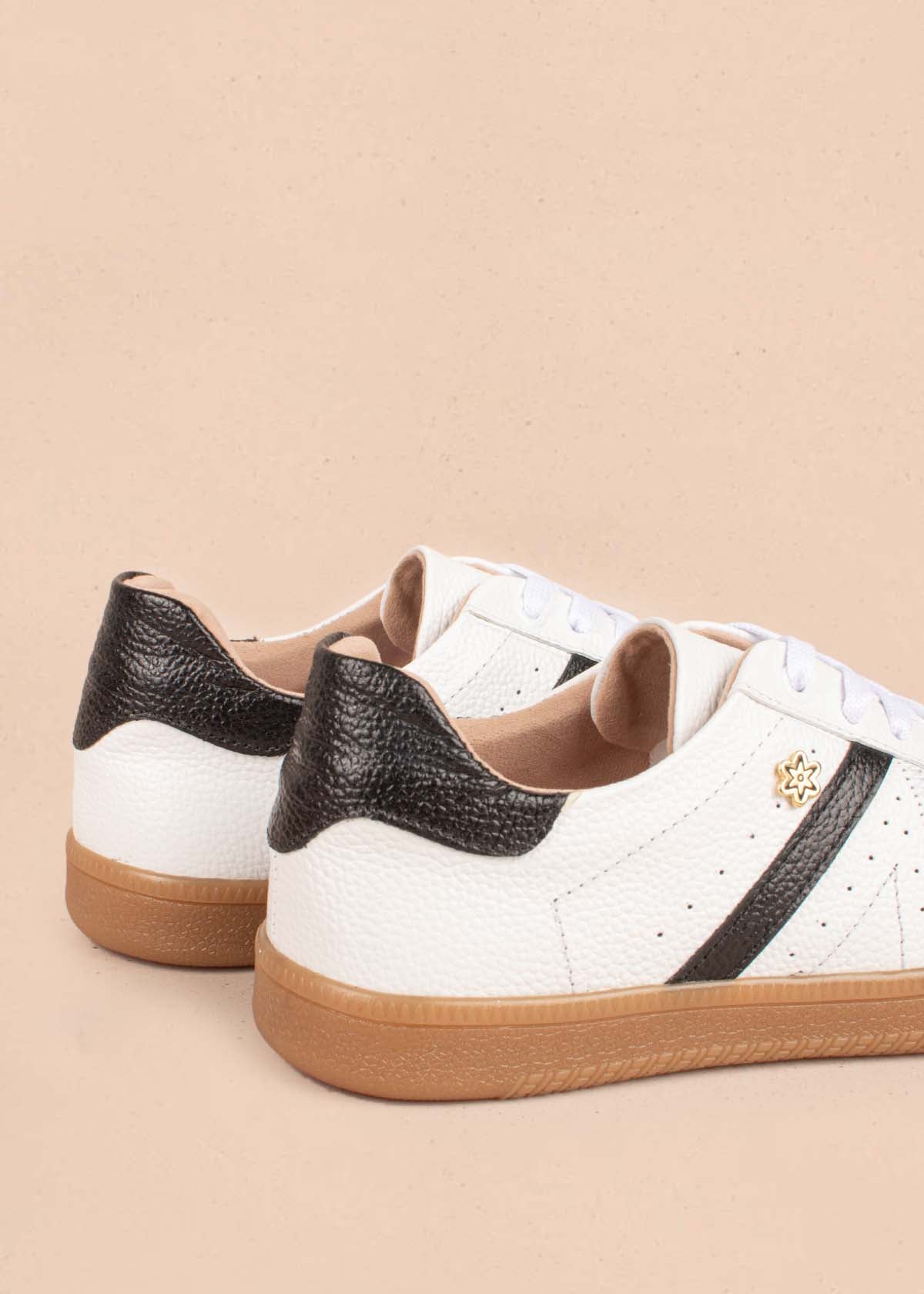 Tenis casuales en cuero color blanco detalles negros 104999