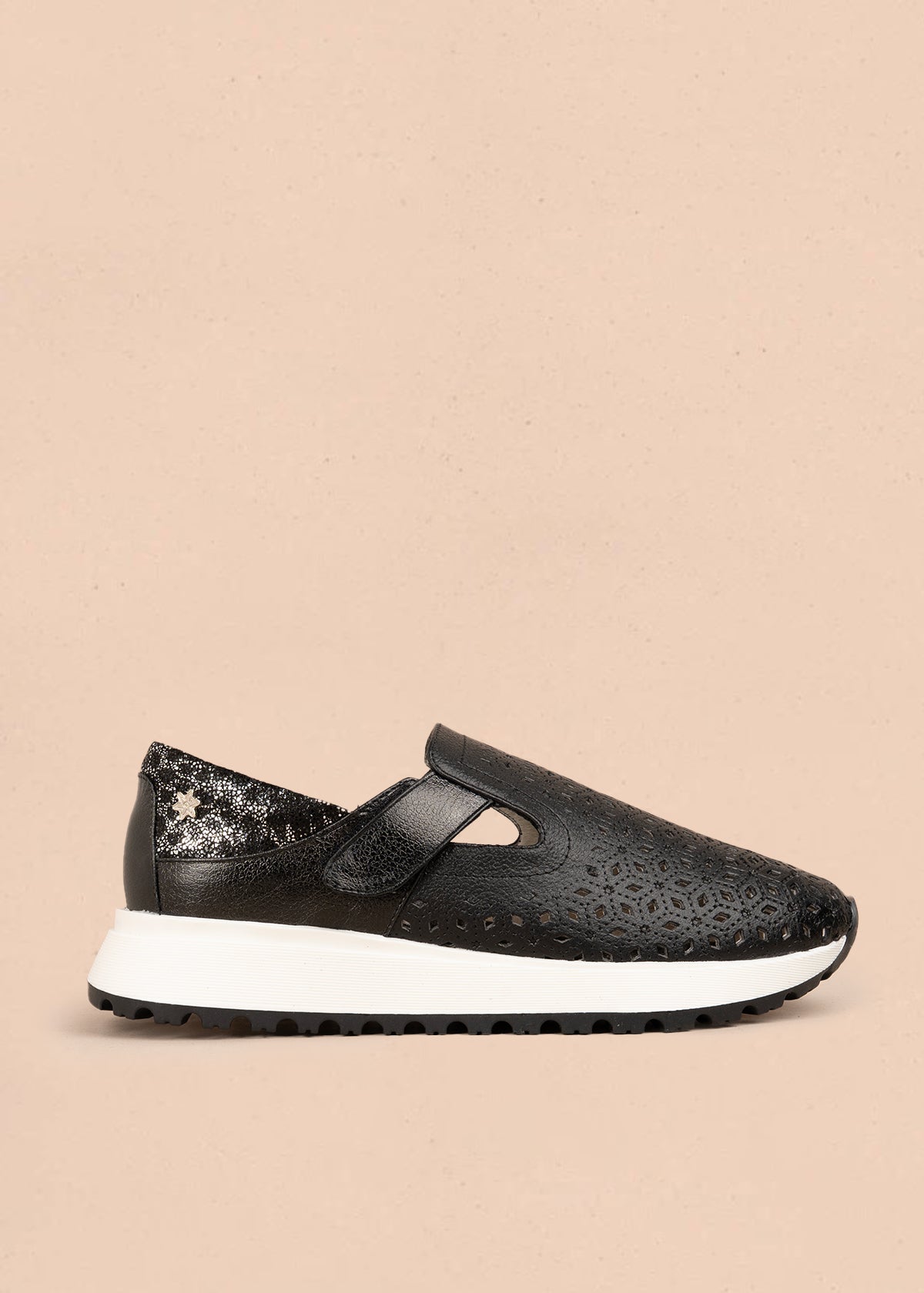 Zapato cerrado en cuero color negro con talón dorado y patrón troquelado  106018
