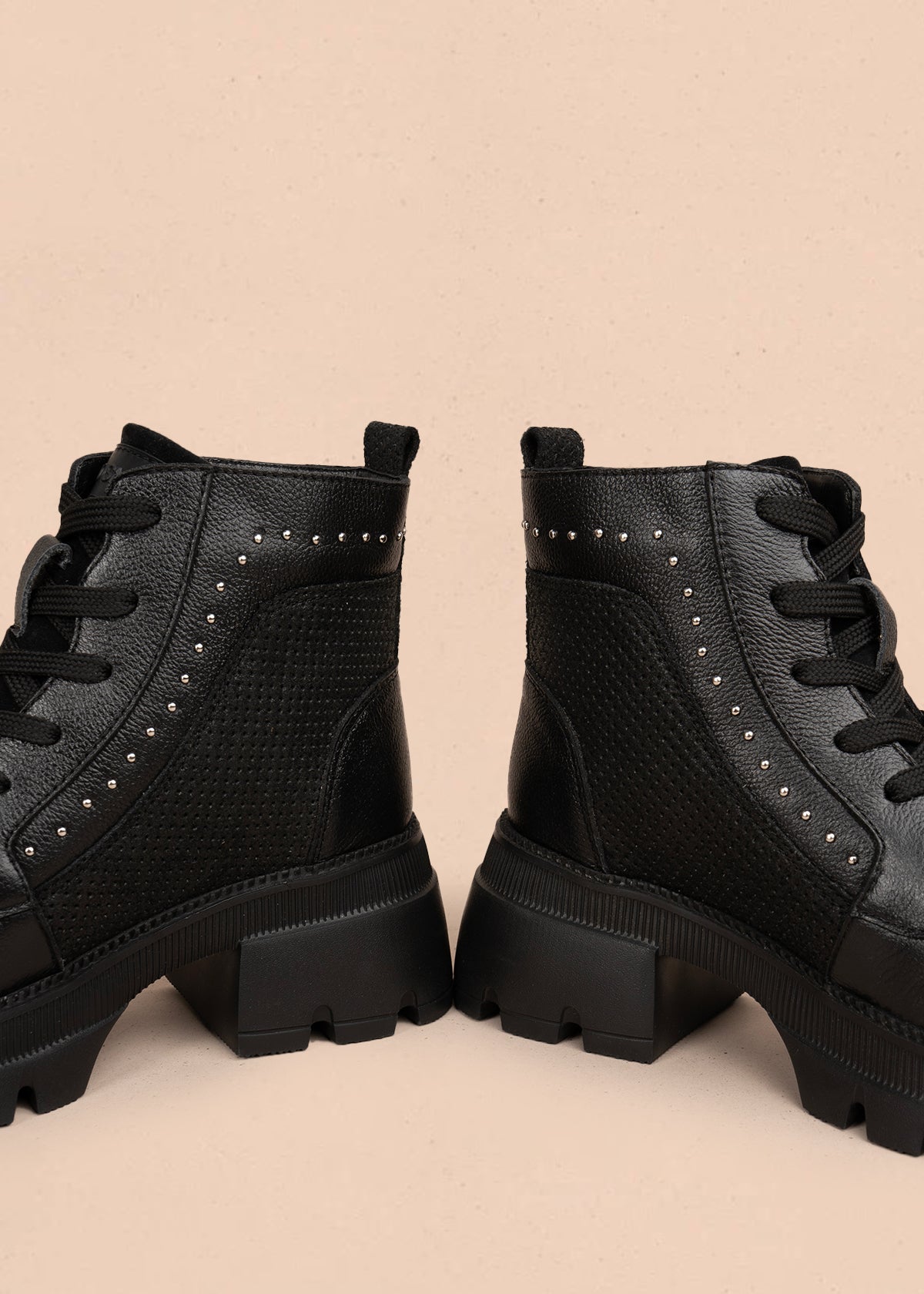 Botín en cuero color negro con diseño perforado y detalles metálicos 106118