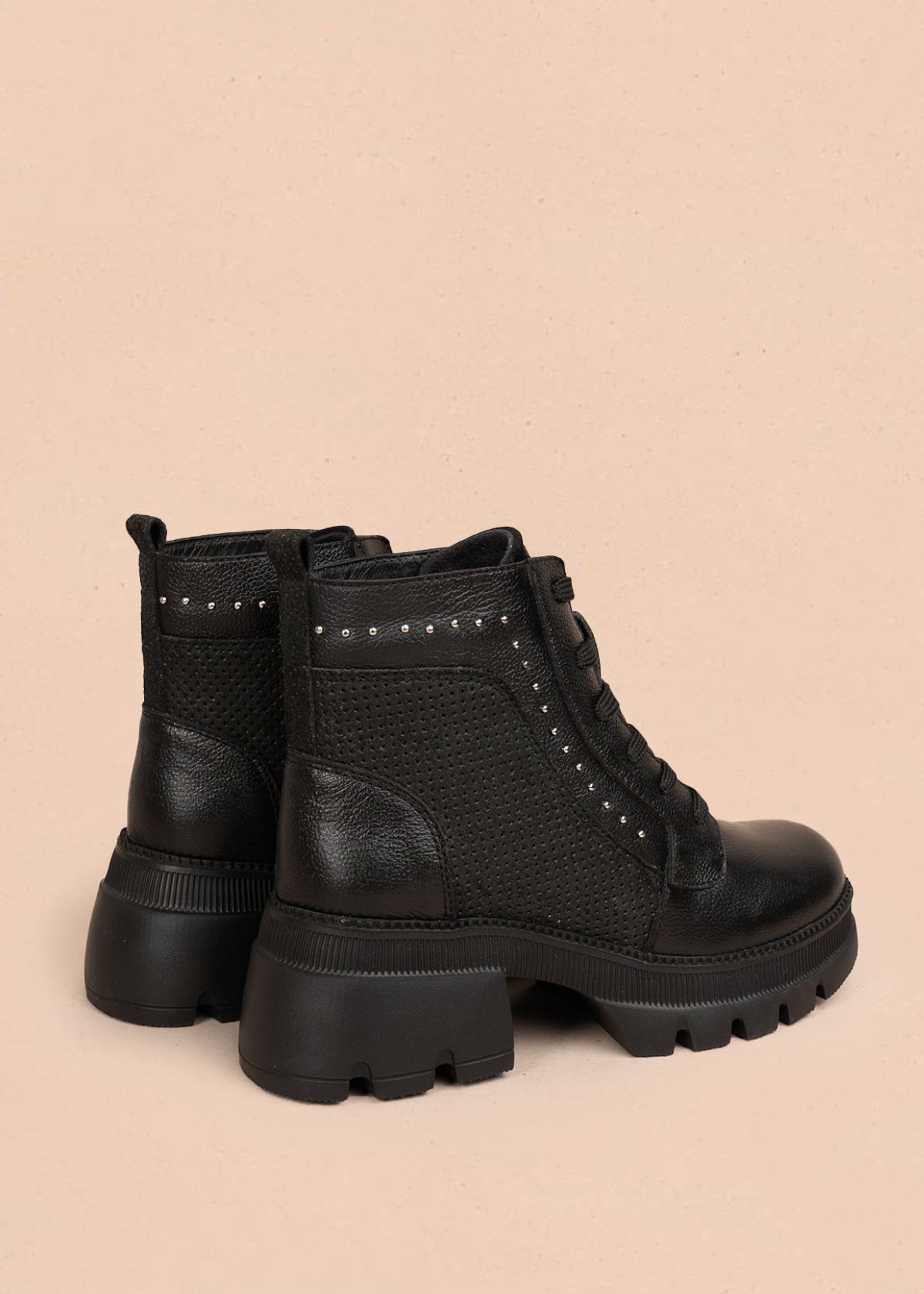 Botín en cuero color negro con diseño perforado y detalles metálicos 106118