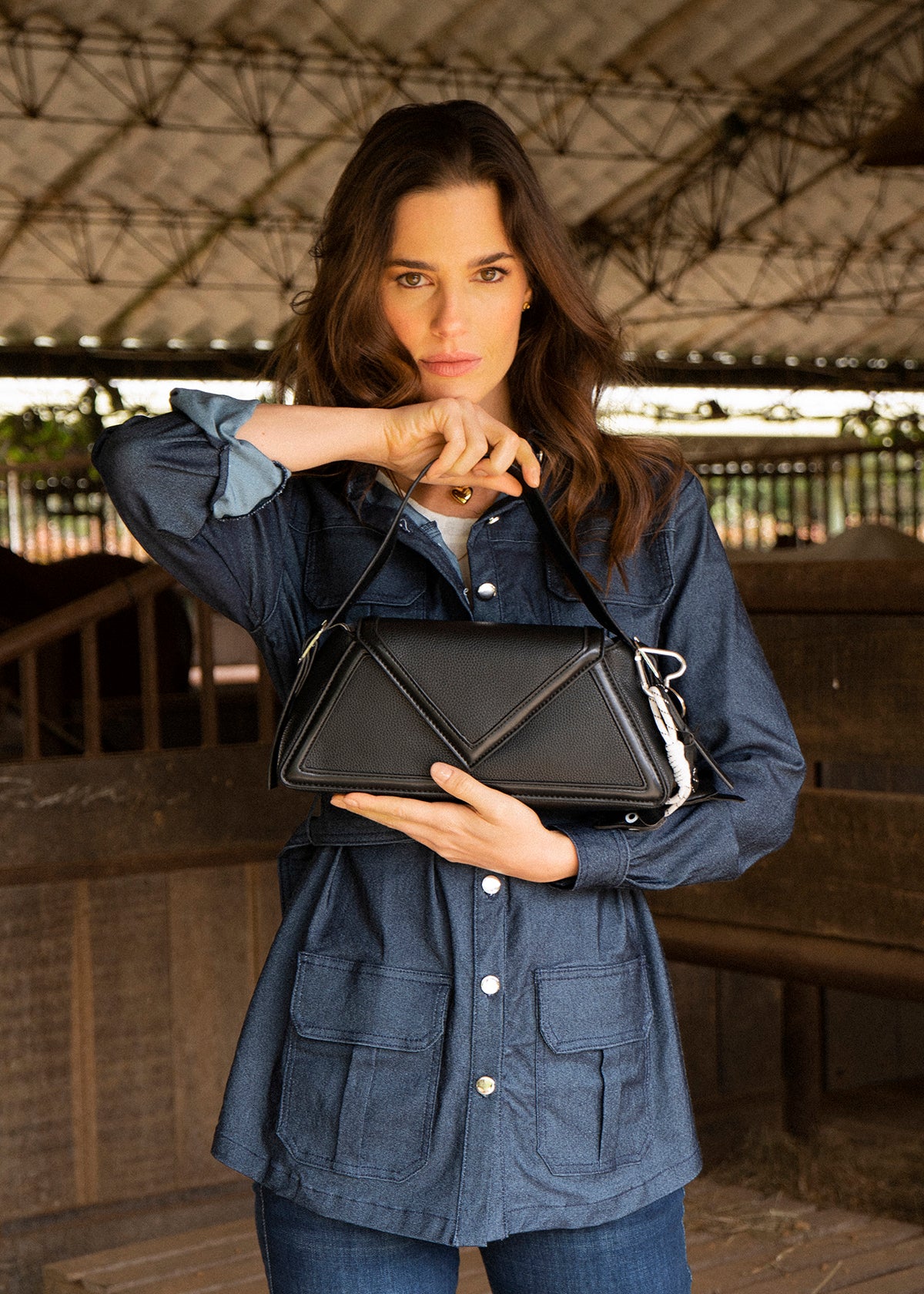 Bolso cartera color negro con diseño triangular y acabados metálicos 106179