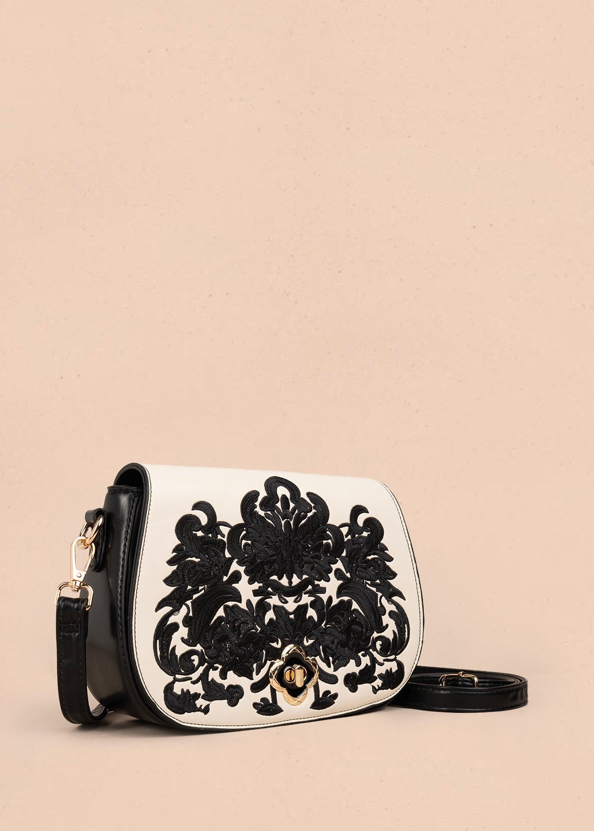 Bolso manos libres color negro con bordado y detalles dorados 106180