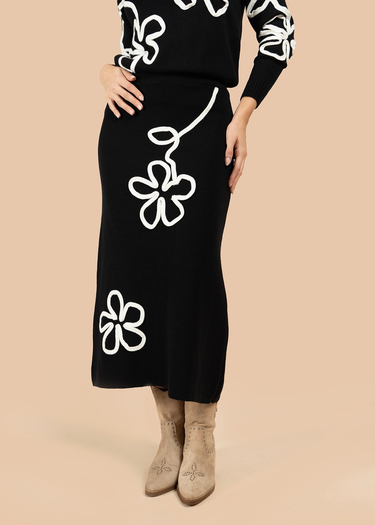 Falda color negro con estampado de flor blanca en cintura y bajo 106193