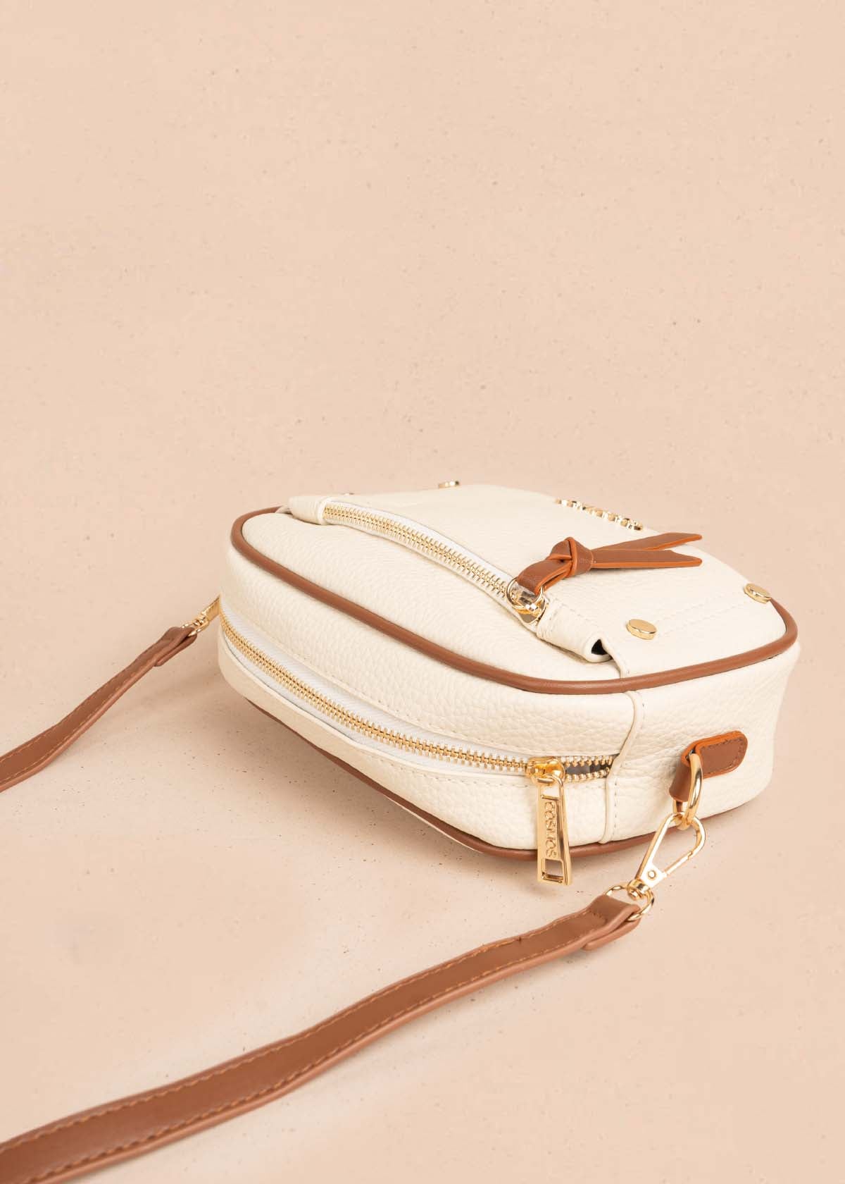 Bolso manos libres color crema bicolor con ribete y tachuelas doradas 106332