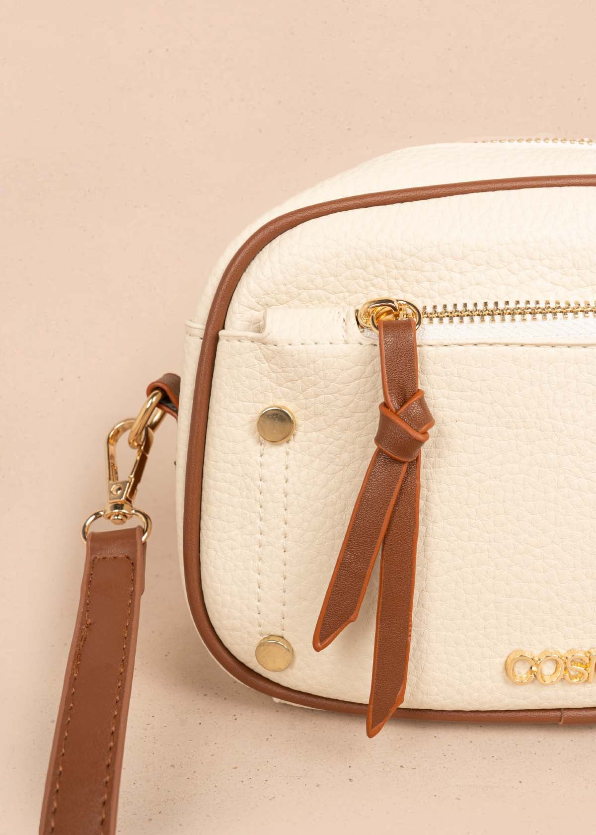 Bolso manos libres color crema bicolor con ribete y tachuelas doradas 106332