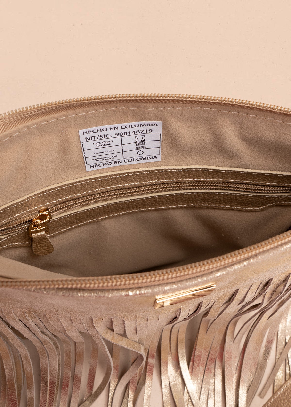 Bolso manos libres de cuero color arena con flecos 106633