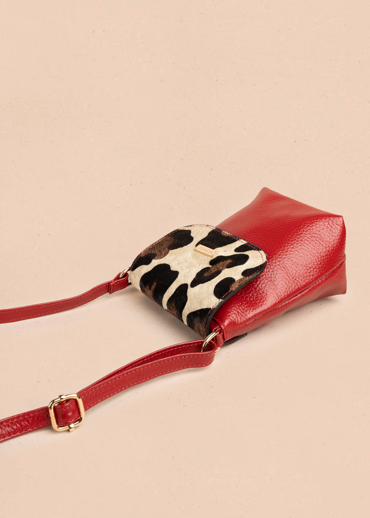 Bolso manos libres de cuero color rojo con tapa leopardo 106648
