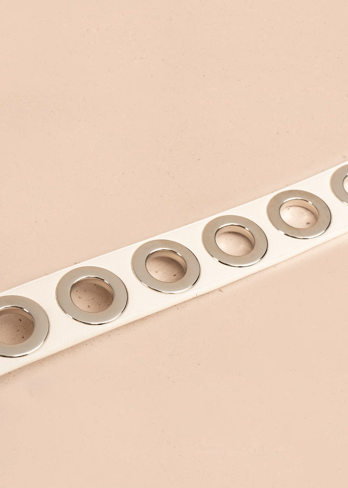 Cinturón de cuero beige con ojales plateados 106897
