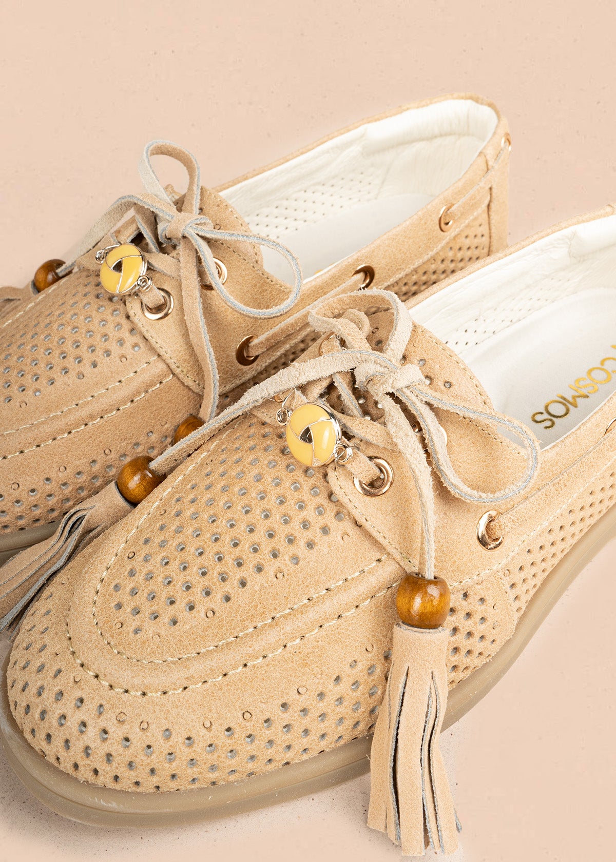 Mocasín en cuero color beige con calado, cordón y borlas 106926