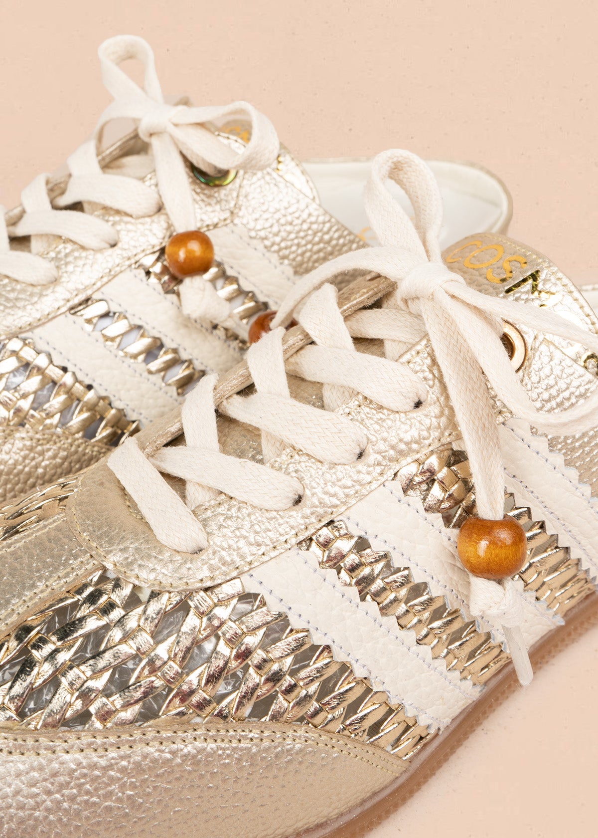 Zuecos en cuero color dorado con tejido, detalle leopardo y cordón con cuenta de madera 106932