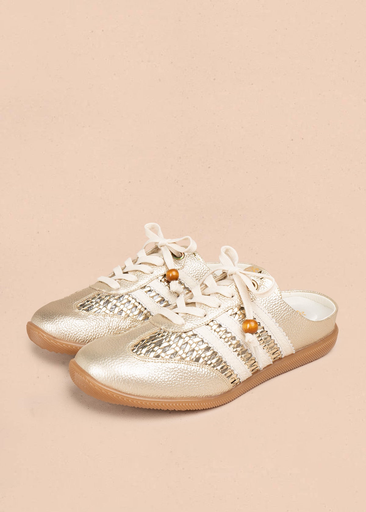 Zuecos en cuero color dorado con tejido, detalle leopardo y cordón con cuenta de madera 106932