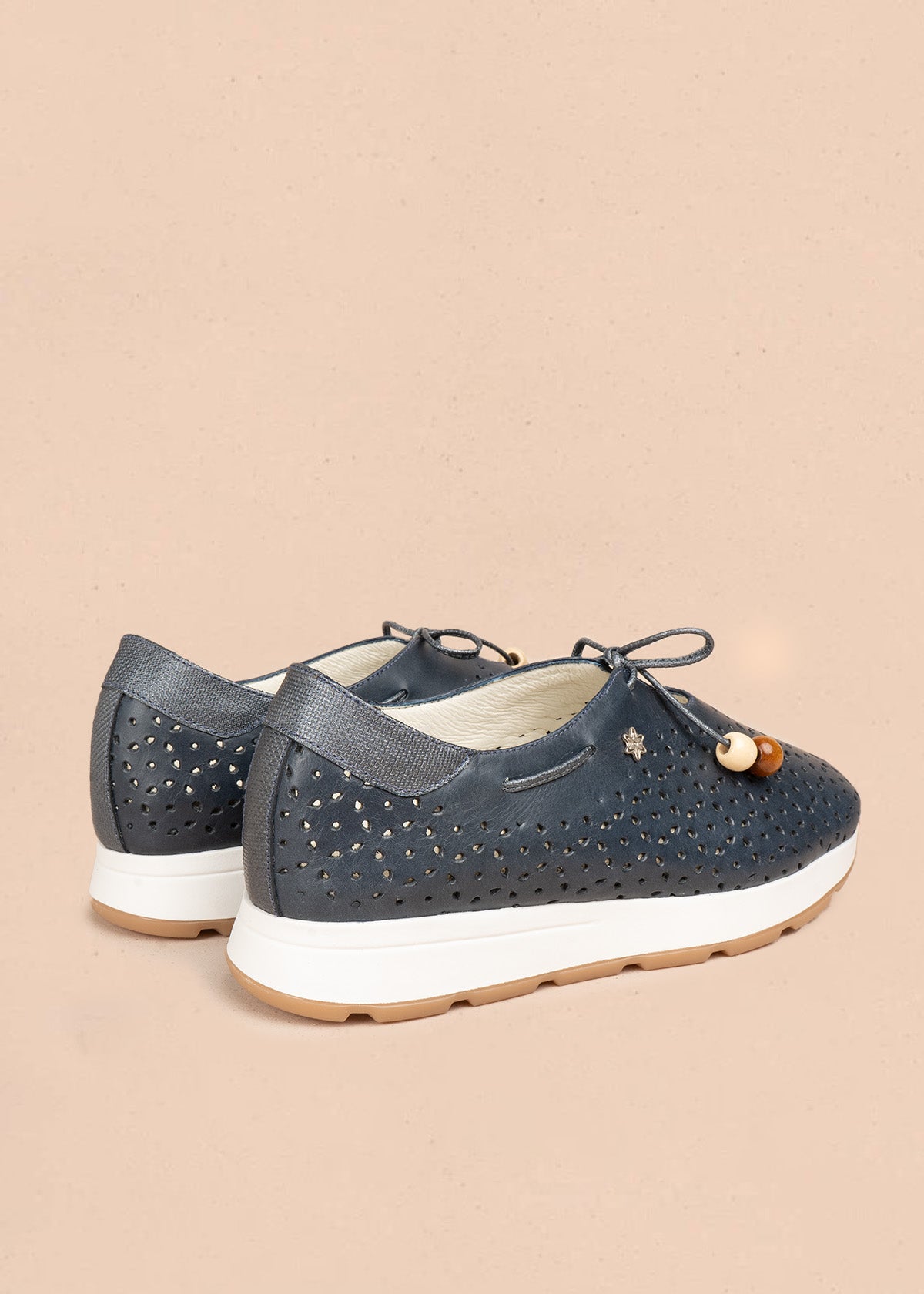 Atadura en cuero color azul con calados en gota y cordón de madera 106935