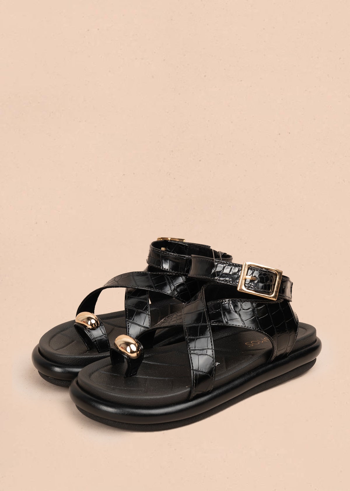 Sandalia plana color negro con correas cruzadas y detalle metálico dorado 106957