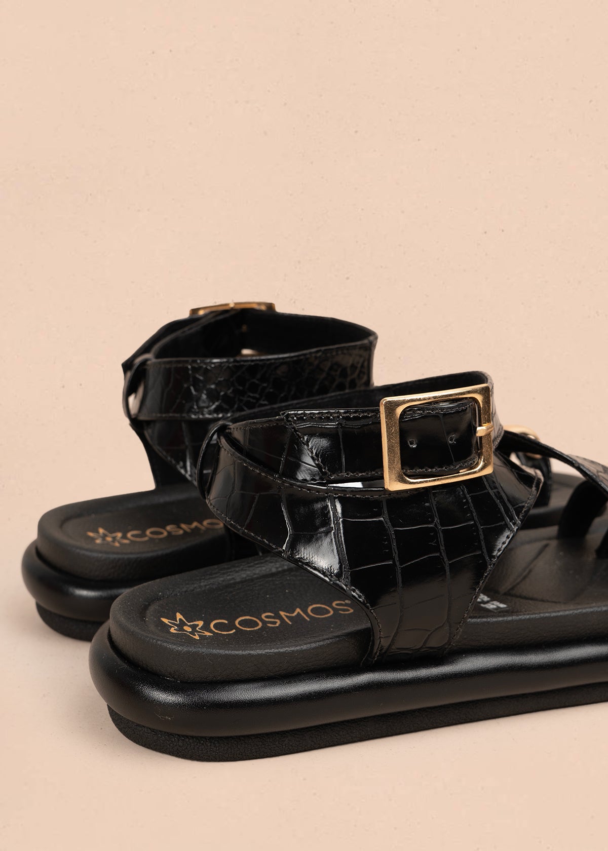 Sandalia plana color negro con correas cruzadas y detalle metálico dorado 106957