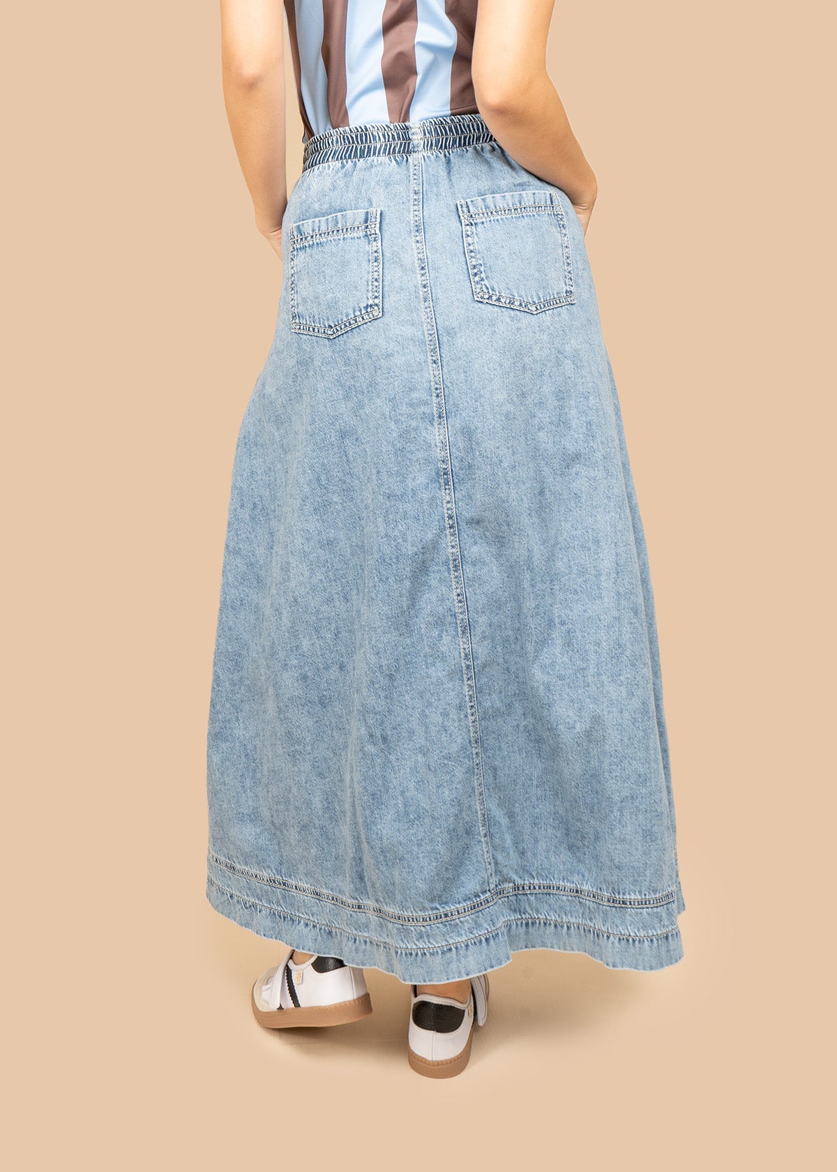 Falda larga en denim claro con botonadura frontal y costuras en ángulo 107035