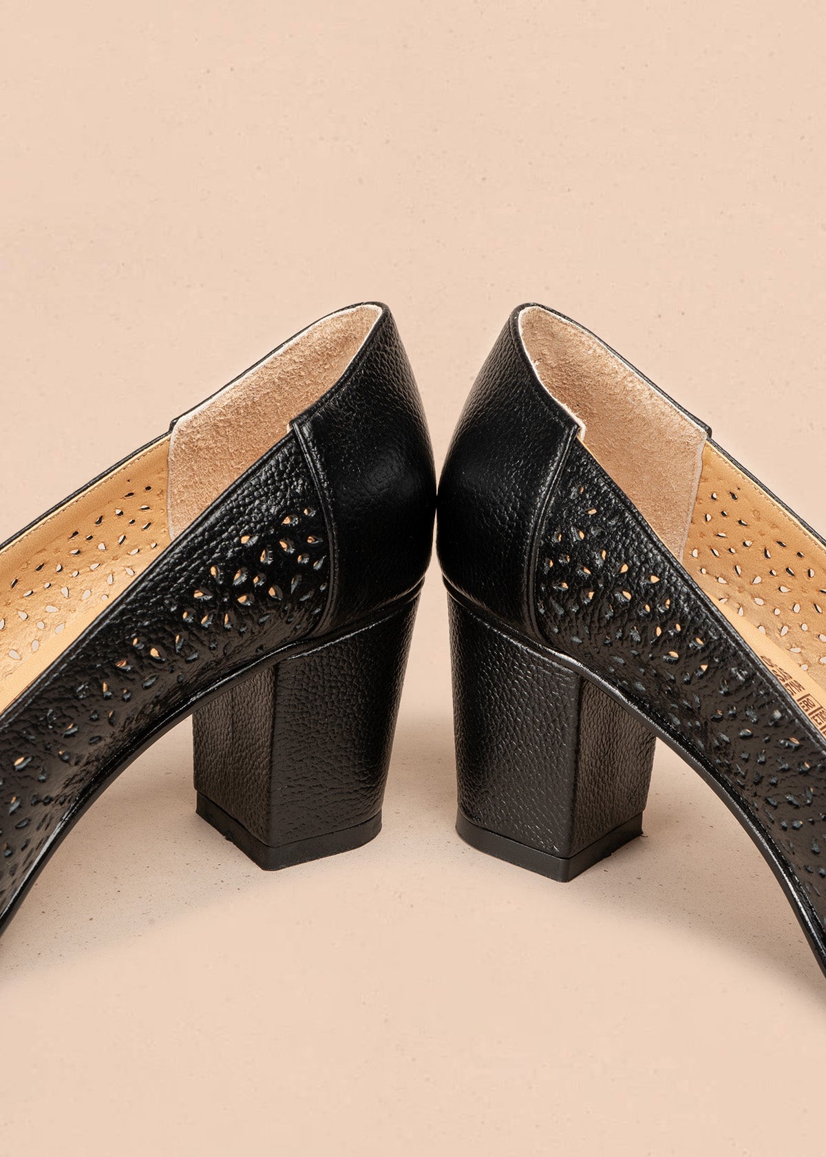 Tacones de cuero color negro con textura de huecos, moño decorativo y tacón grueso 107047