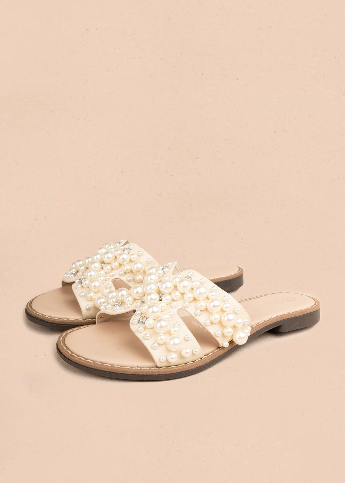 Sandalia plana en polipiel color beige con tiras cruzadas y perlas 107115